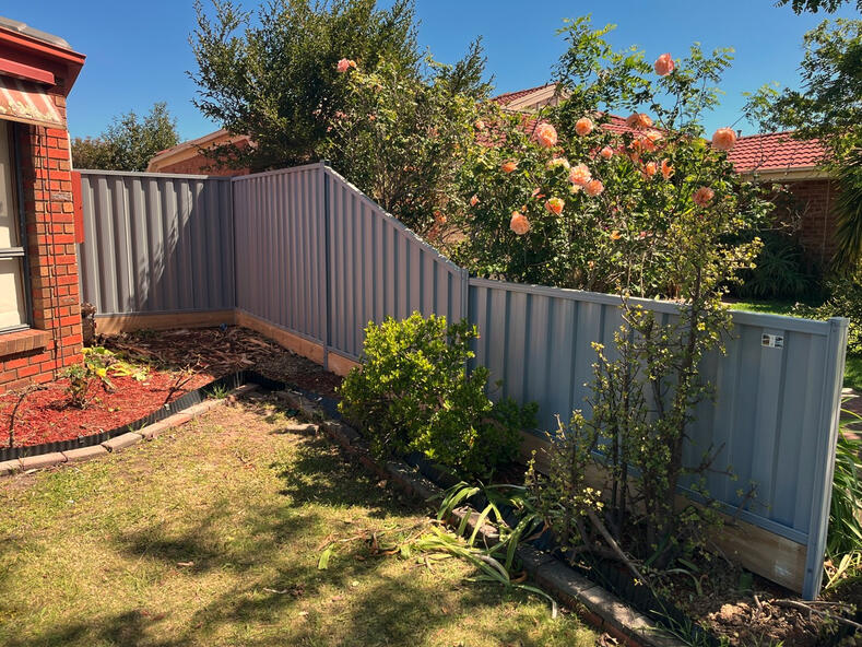 Sloped Colorbond Fence with Timber Sleepers Installation in Clyde sloped Colorbond fence with timber sleepers Bluegum colour installed in Clyde