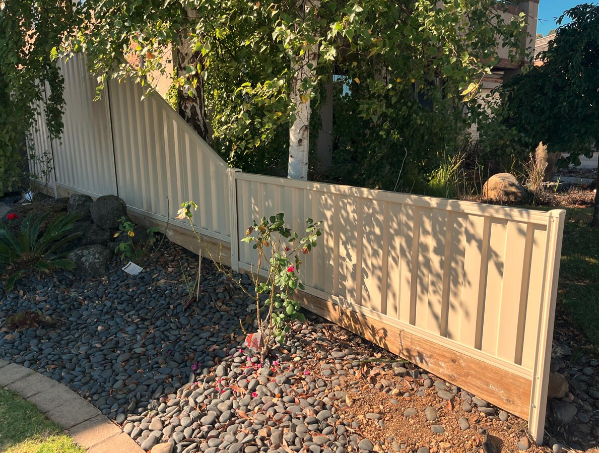 Sloped Colorbond Fence with Timber Sleepers Installation in Clyde North sloped Colorbond fence with timber sleepers Paperbark colour installed in Clyde North